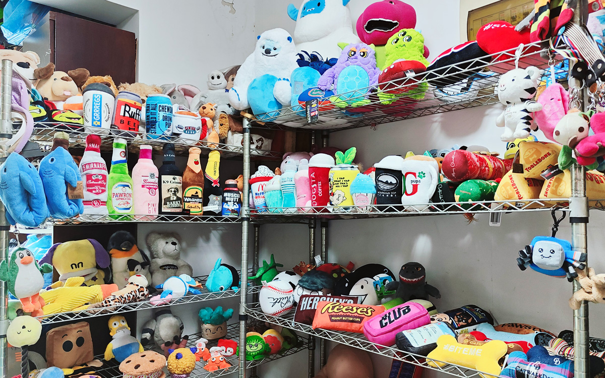 Custom pet toys bulk samples on metal shelves in OEM factory