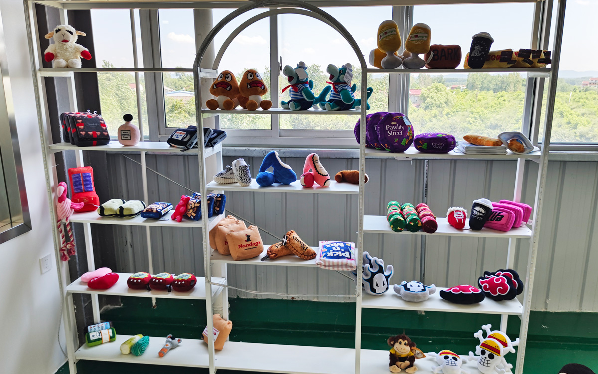 Pet plush toy samples displayed on factory gallery shelves